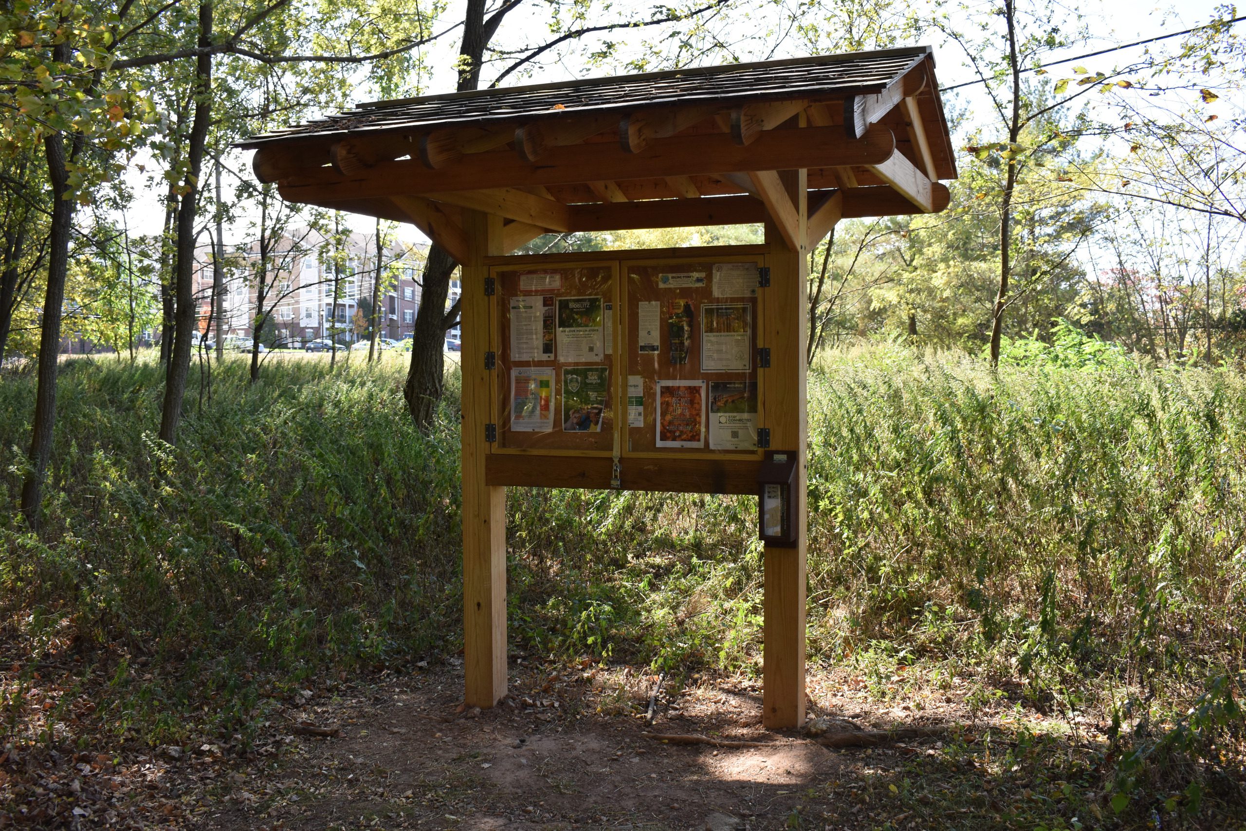 Trail kiosk with a wooden roof and map display at the Red Trail entrance.