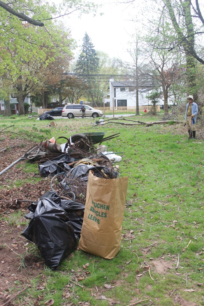 More collected debris including bags and loose items, in a grassy area.